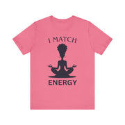 Pink t-shirt with a black silhouette of a person in a meditative pose and text 'I MATCH ENERGY' on a white background.