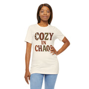 Woman wearing a white t-shirt with 'COZY IN CHAOS' text on a white background
