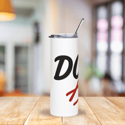 White tumbler with black and red design on a wooden table with a blurred background