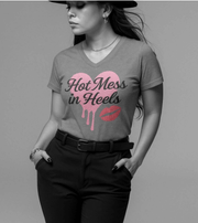 Woman wearing a gray t-shirt with pink heart and text design on a plain background
