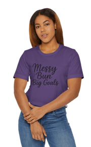 Person wearing a purple t-shirt with 'Messy Bun Big Goals' text on a white background