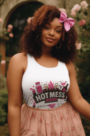 Woman wearing a white tank top with 'Hot Mess' text and graphics, standing outdoors with flowers in the background.