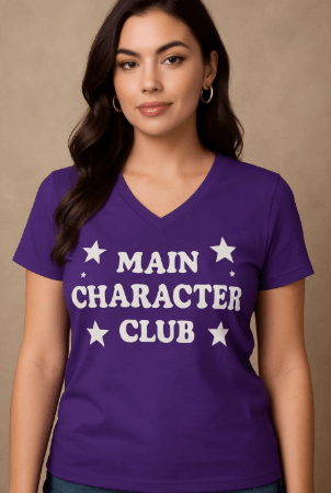 Woman wearing a purple t-shirt with 'MAIN CHARACTER CLUB' text and stars on a beige background