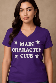 Woman wearing a purple t-shirt with 'MAIN CHARACTER CLUB' text and stars on a beige background
