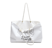 White tote bag with 'Divine energy' text on a white background