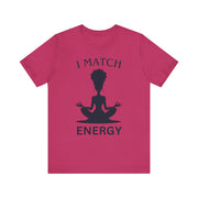 Pink t-shirt with a black silhouette of a person in meditation and text 'I MATCH ENERGY' on a white background.
