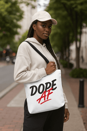 Woman holding a tote bag with 'Dope AF' text on a city street.