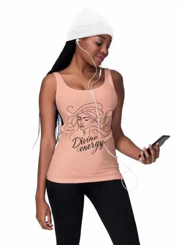 Woman wearing a tank top with 'Divine energy' text and listening to music on earphones.