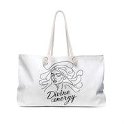 White tote bag with a black line drawing of a woman's face and 'Divine energy' text on a white background