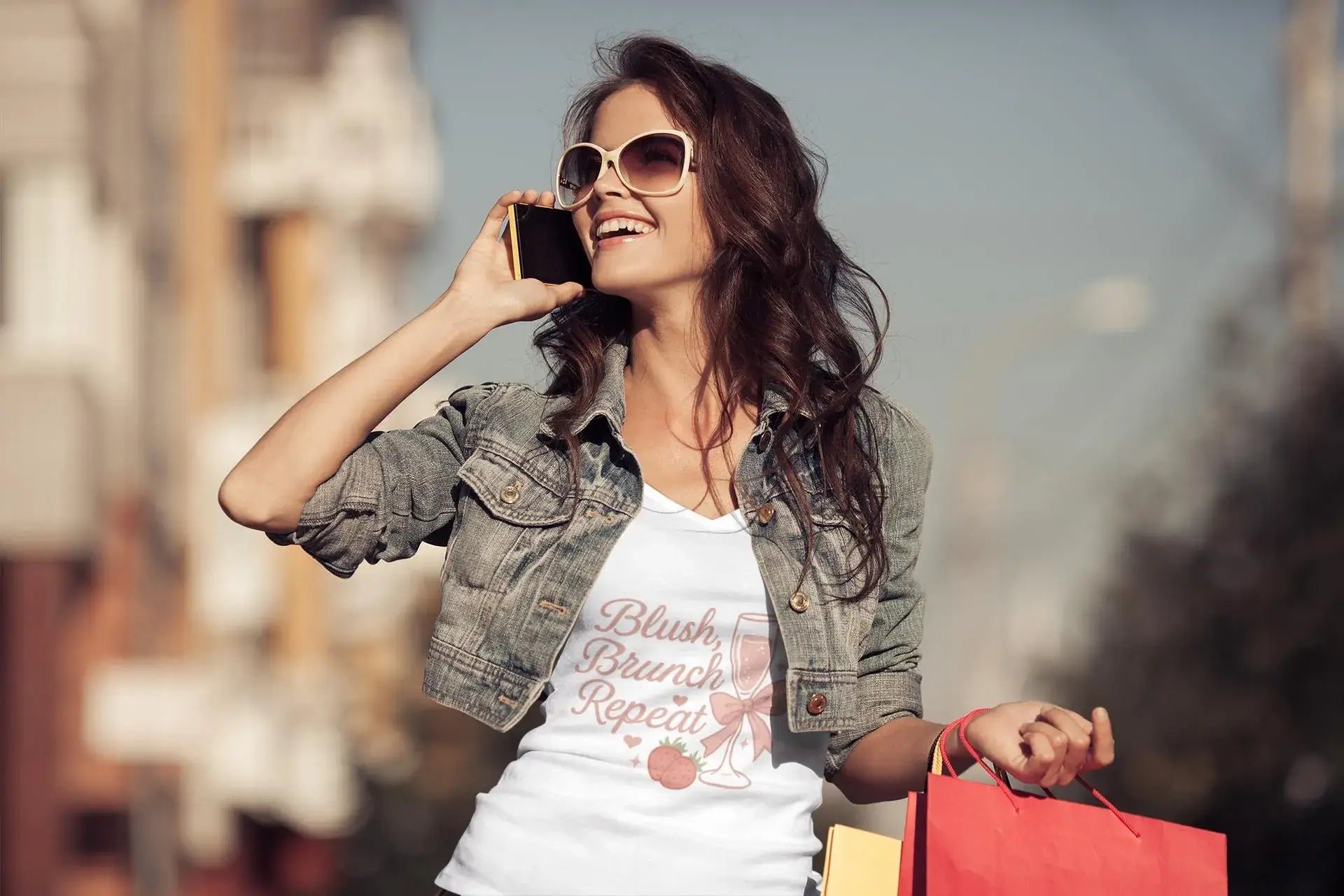 Woman talking on phone with shopping bags in an urban setting