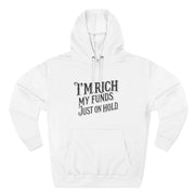 White hoodie with text 'I'm rich, my funds just on hold' on a white background