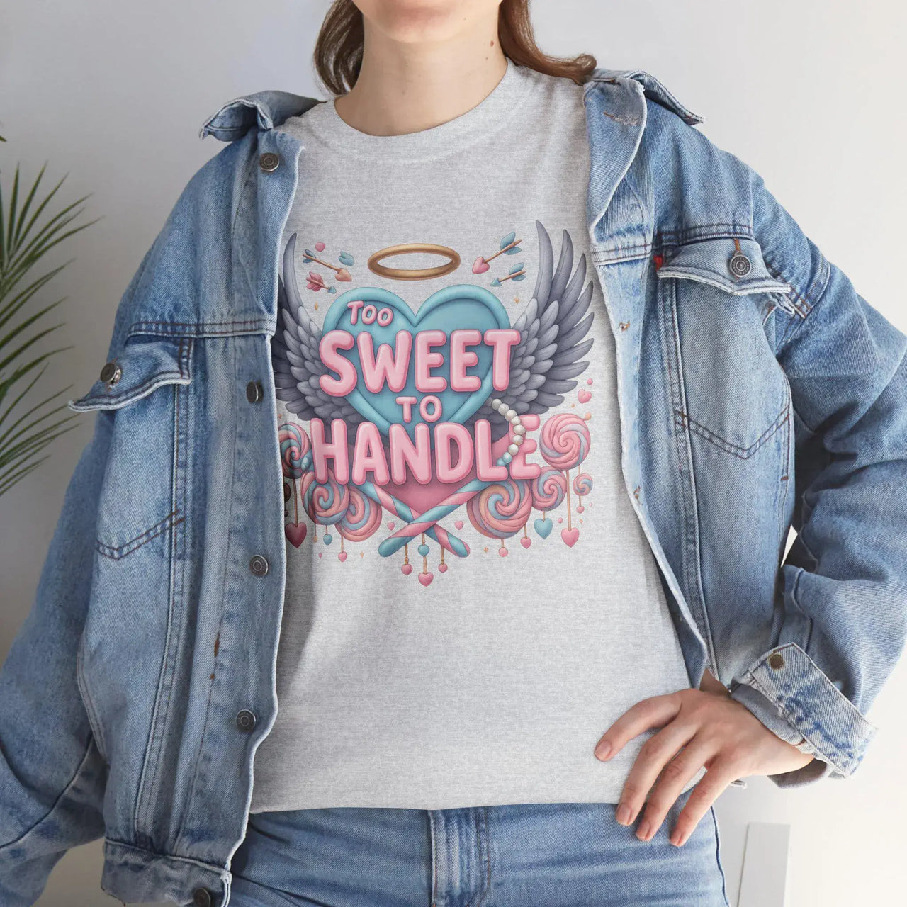 Person wearing a gray t-shirt with a colorful graphic and text, paired with a denim jacket.
