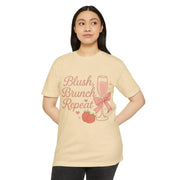 Woman wearing a beige t-shirt with 'Blush, Brunch, Repeat' text and graphics on a white background