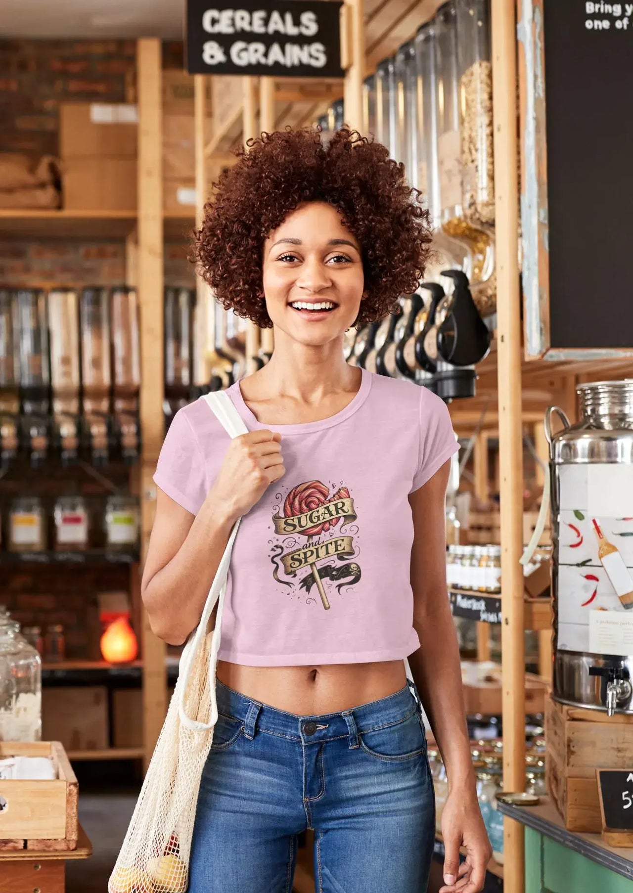 Woman in a store wearing a pink t-shirt with a graphic design.
