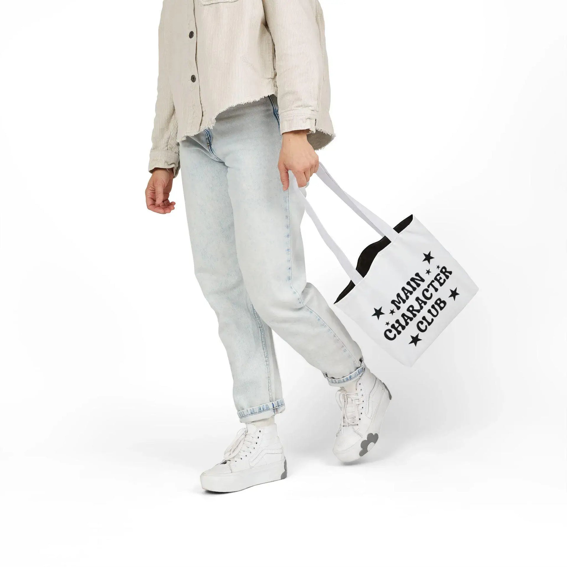 Person holding a tote bag with text on a white background
