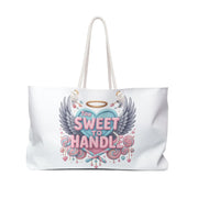 White tote bag with a colorful design featuring a heart, wings, and text on a white background