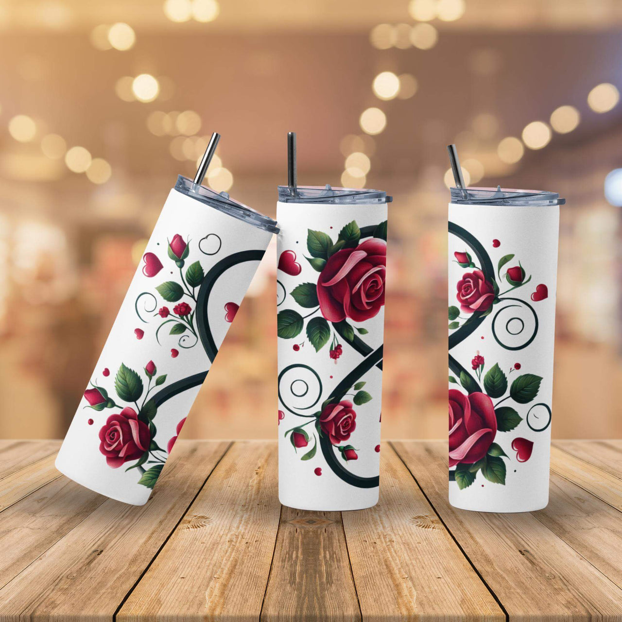 Three white tumblers with floral designs on a wooden surface with a blurred background.