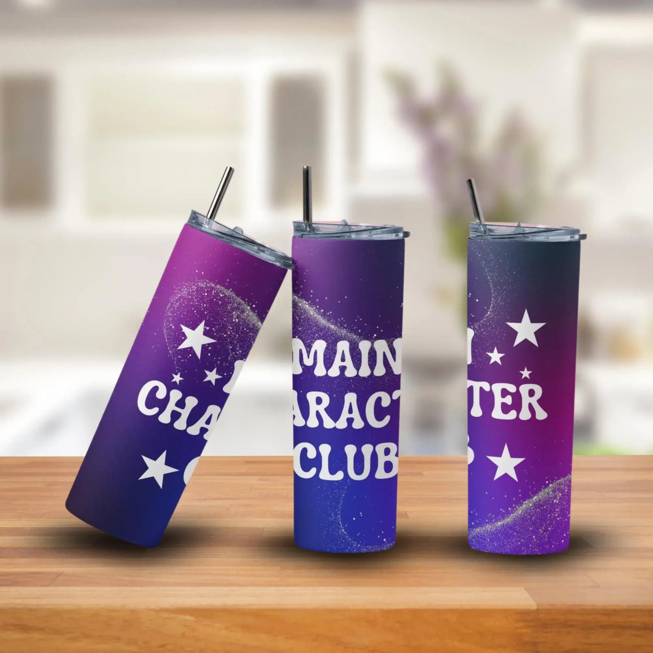 Three purple tumblers with star designs and text on a wooden surface.