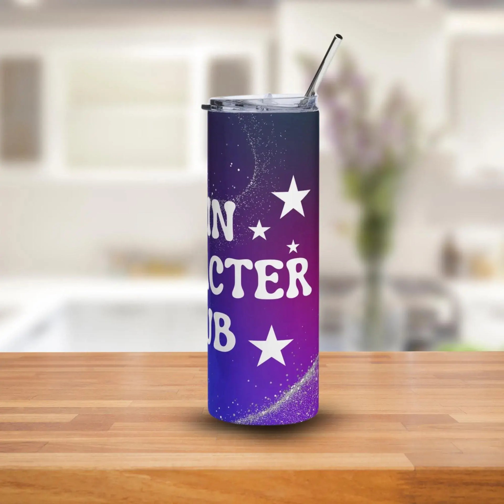 Tumbler with star design and text on a wooden surface with a blurred background