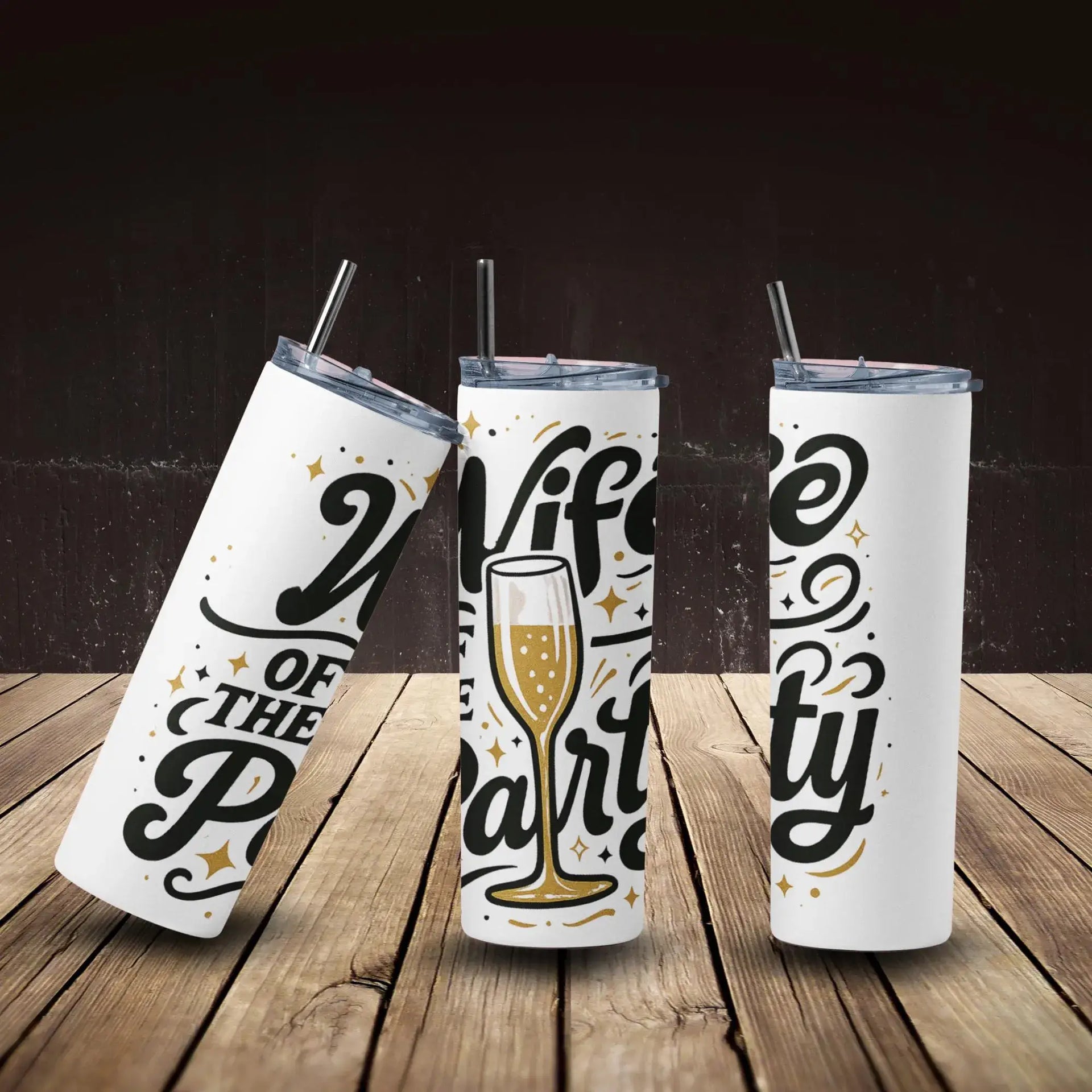 Three white tumblers with black and gold text on a wooden surface and dark background