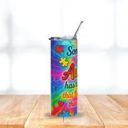 Colorful tumbler with autism awareness design on a wooden surface
