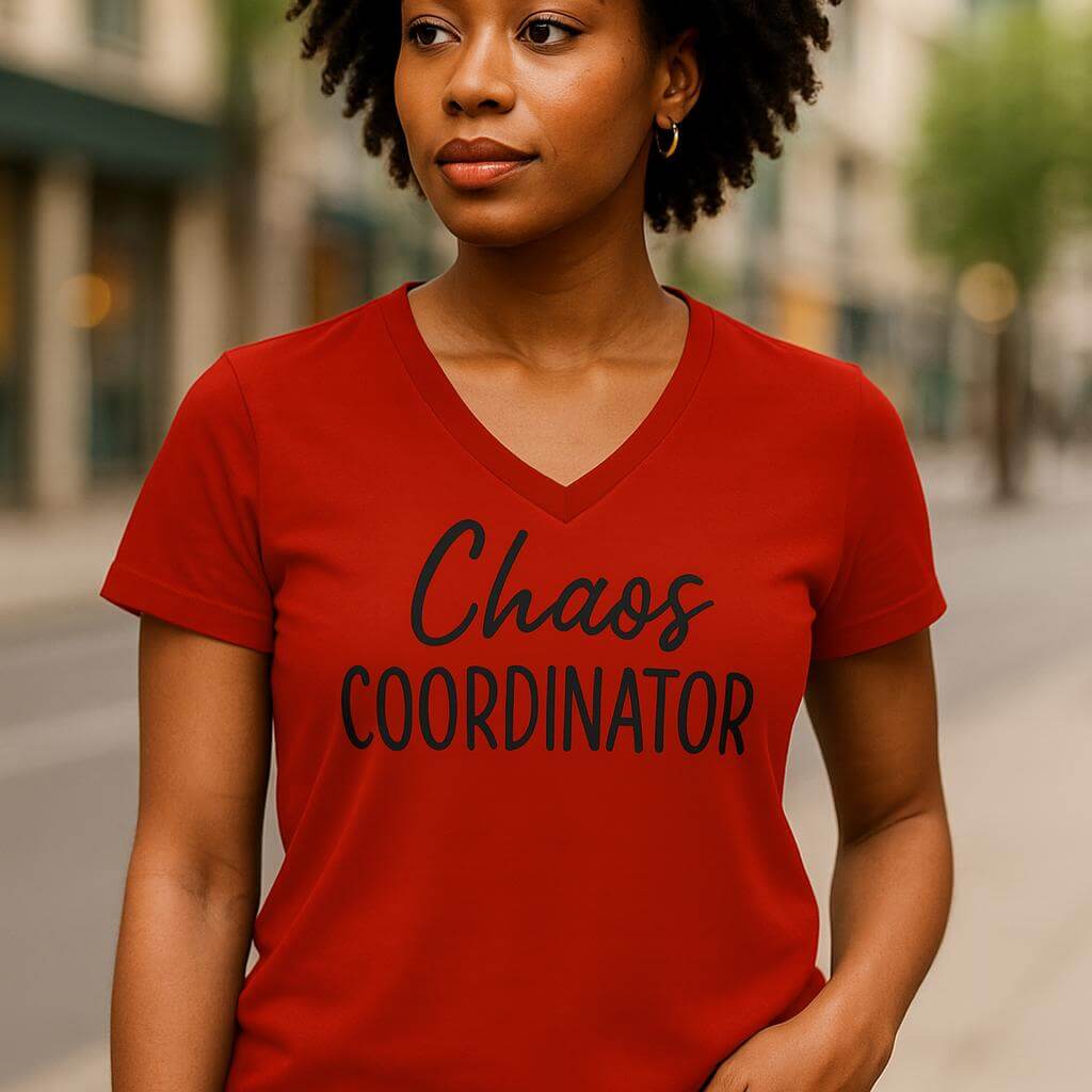 Woman wearing a red t-shirt with 'Chaos Coordinator' text on a blurred street background