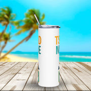 White tumbler with text on a wooden surface with a beach background