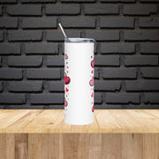 White tumbler with red heart pattern on a wooden surface with black brick wall background