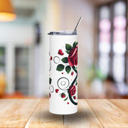 White tumbler with red rose design on a wooden table