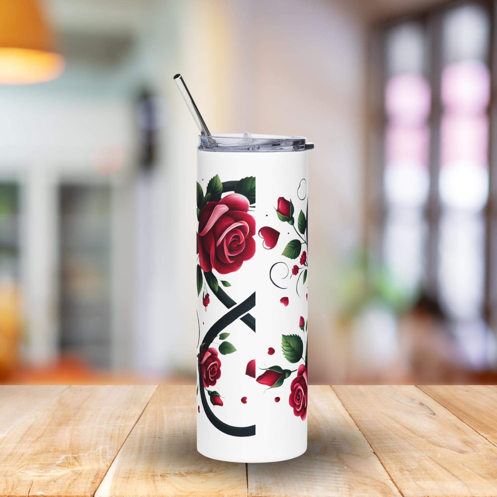 Tumbler with red rose design on a wooden table