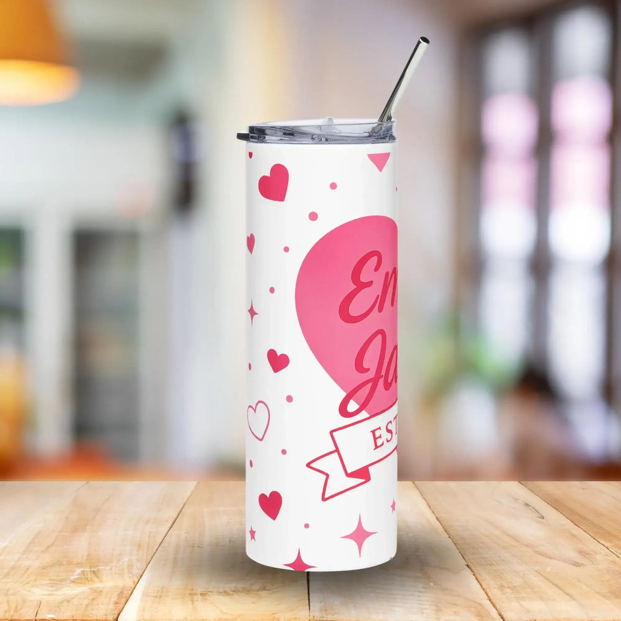 White tumbler with pink heart design and text on a wooden table