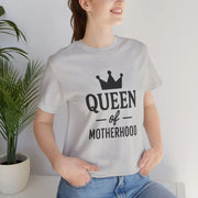 Person wearing a white t-shirt with 'Queen of Motherhood' text and a crown graphic.