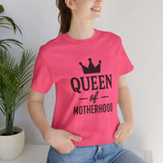 Person wearing a pink t-shirt with 'Queen of Motherhood' text and a crown graphic.