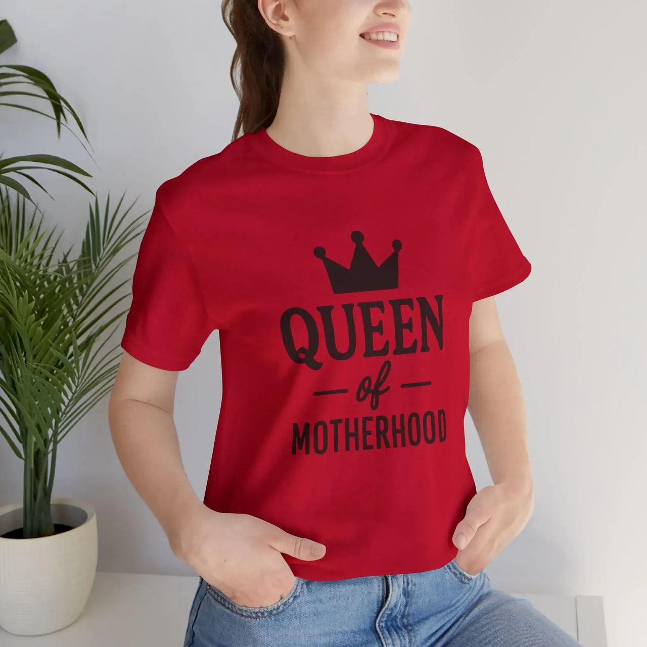 Person wearing a red t-shirt with 'Queen of Motherhood' text and a crown graphic.