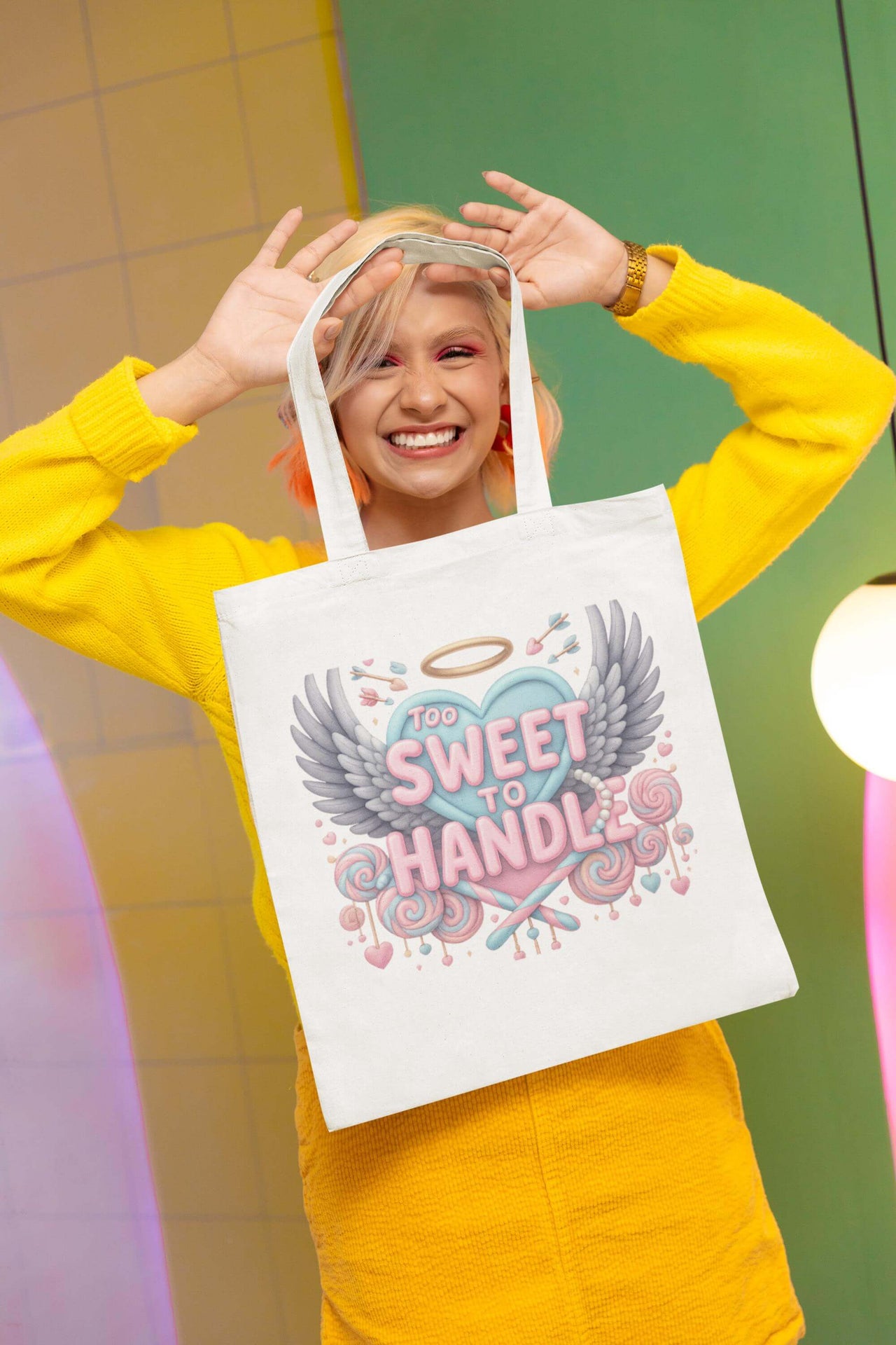 Person holding a tote bag with a colorful design and text.