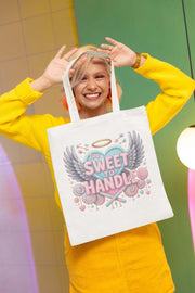 Person holding a tote bag with a colorful design and text.