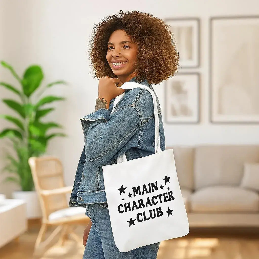 Woman holding a tote bag with 'Main Character Club' text in a living room setting