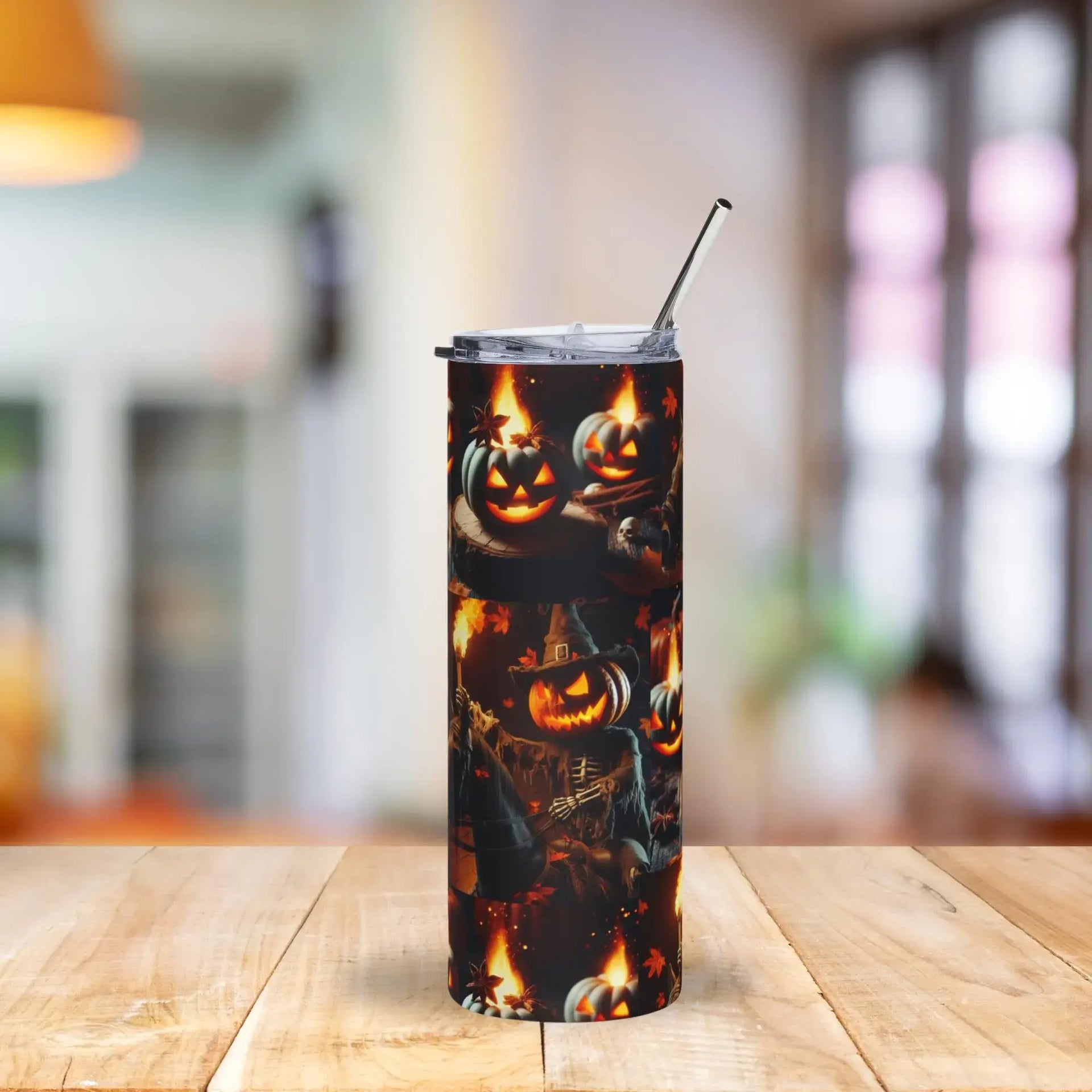 Tumbler with Halloween design featuring pumpkins and a ghost on a wooden table.