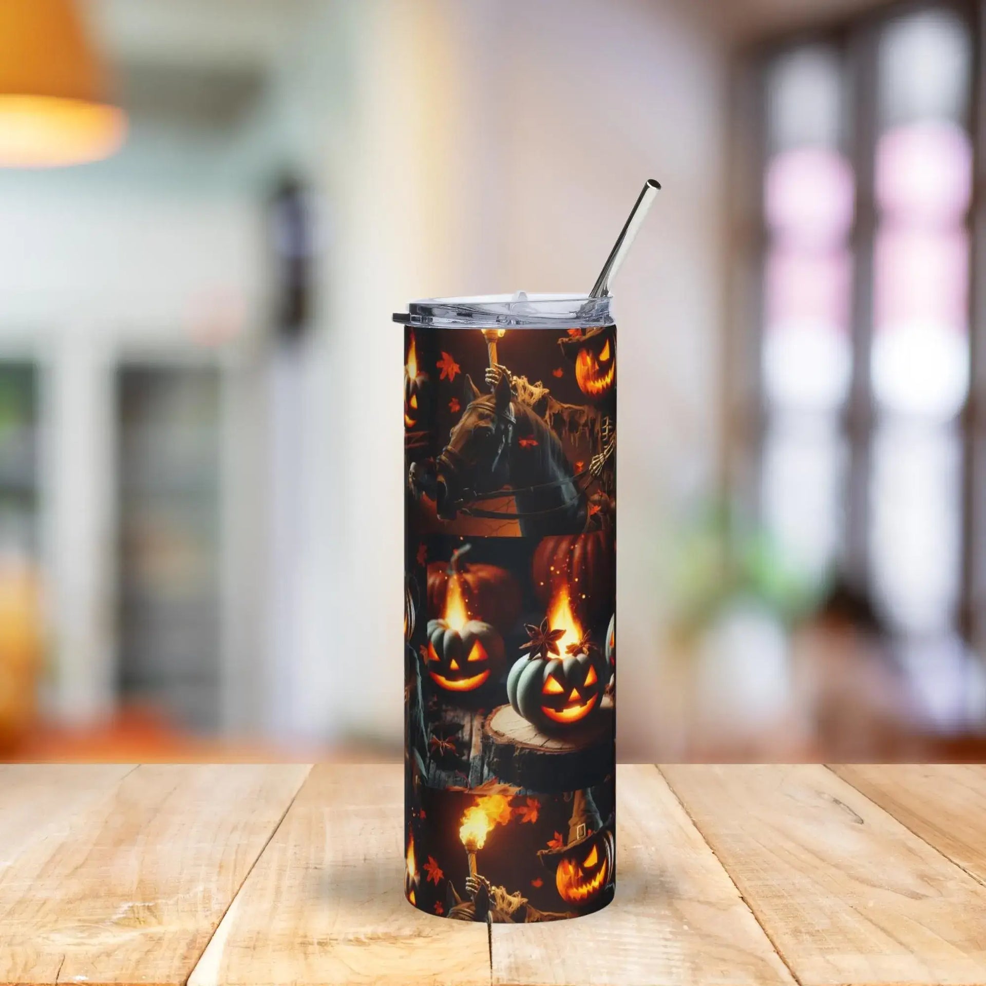 Tumbler with Halloween design featuring pumpkins and ghosts on a wooden table.