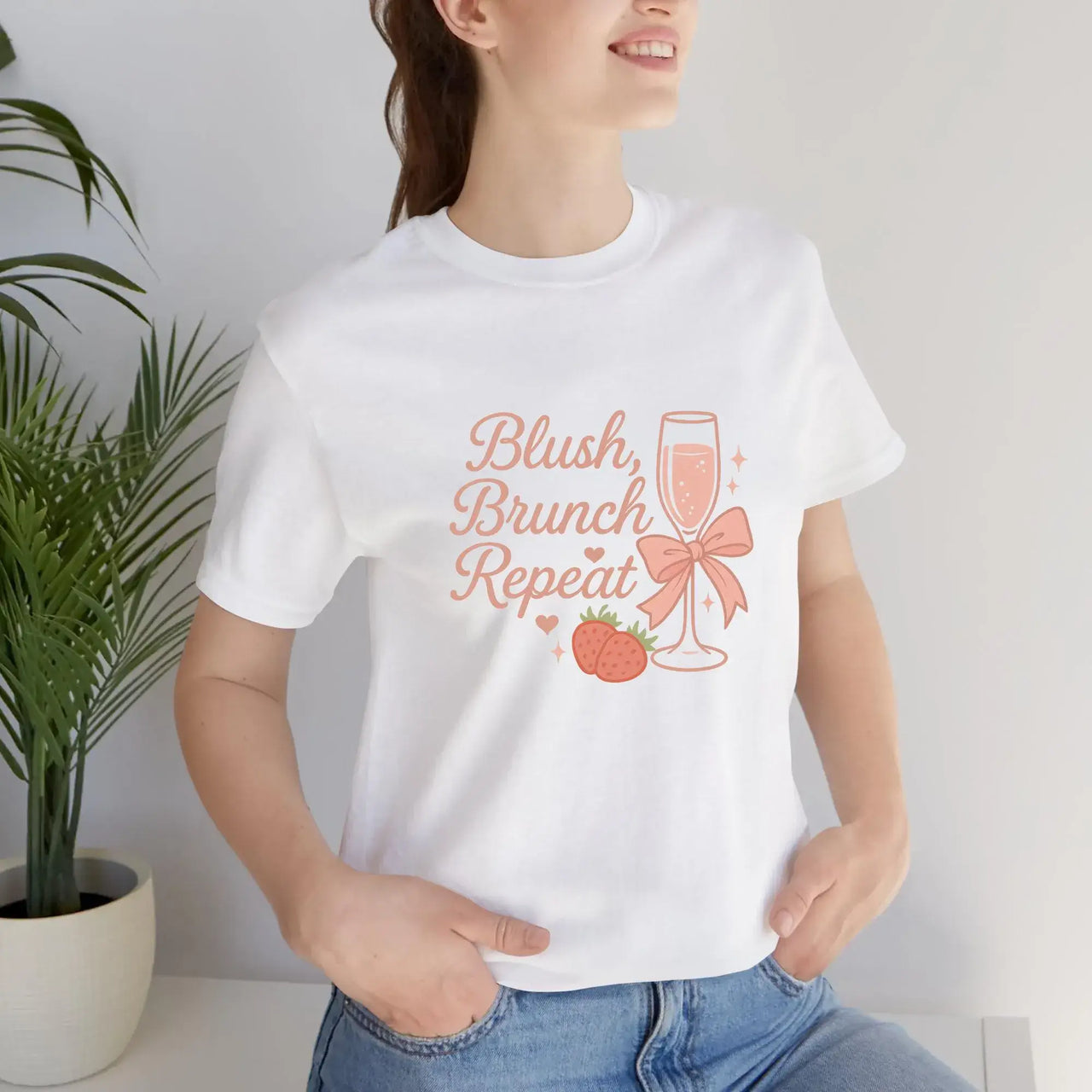 Person wearing a white t-shirt with 'Blush, Brunch, Repeat' design.