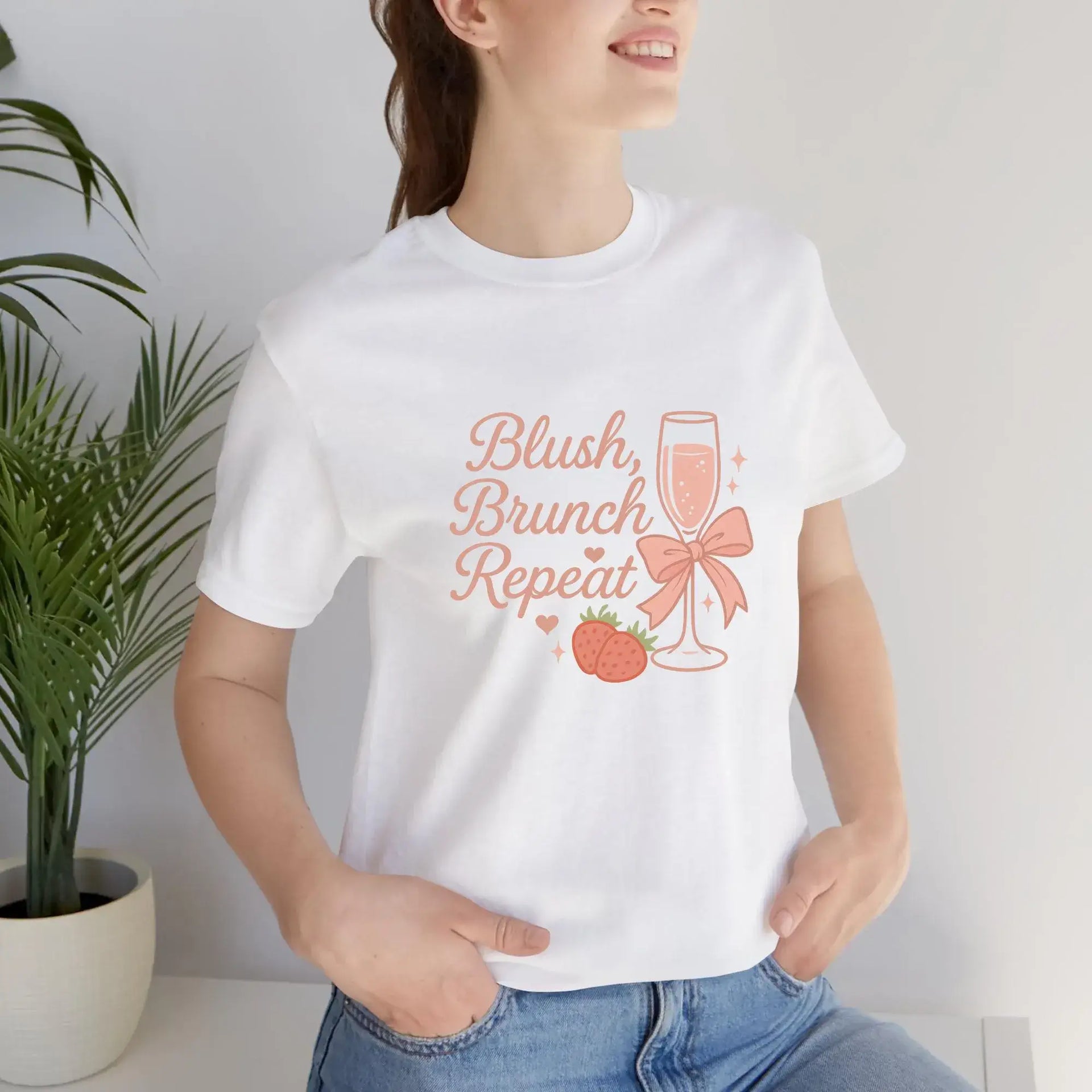 Person wearing a white t-shirt with 'Blush, Brunch, Repeat' design.