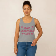 Person wearing a gray tank top with 'MAIN CHARACTER CLUB' text and stars on a beige background