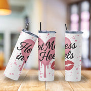Three tumblers with pink heart and lip designs on a wooden surface.