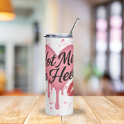 Tumbler with pink heart design and text on a wooden table