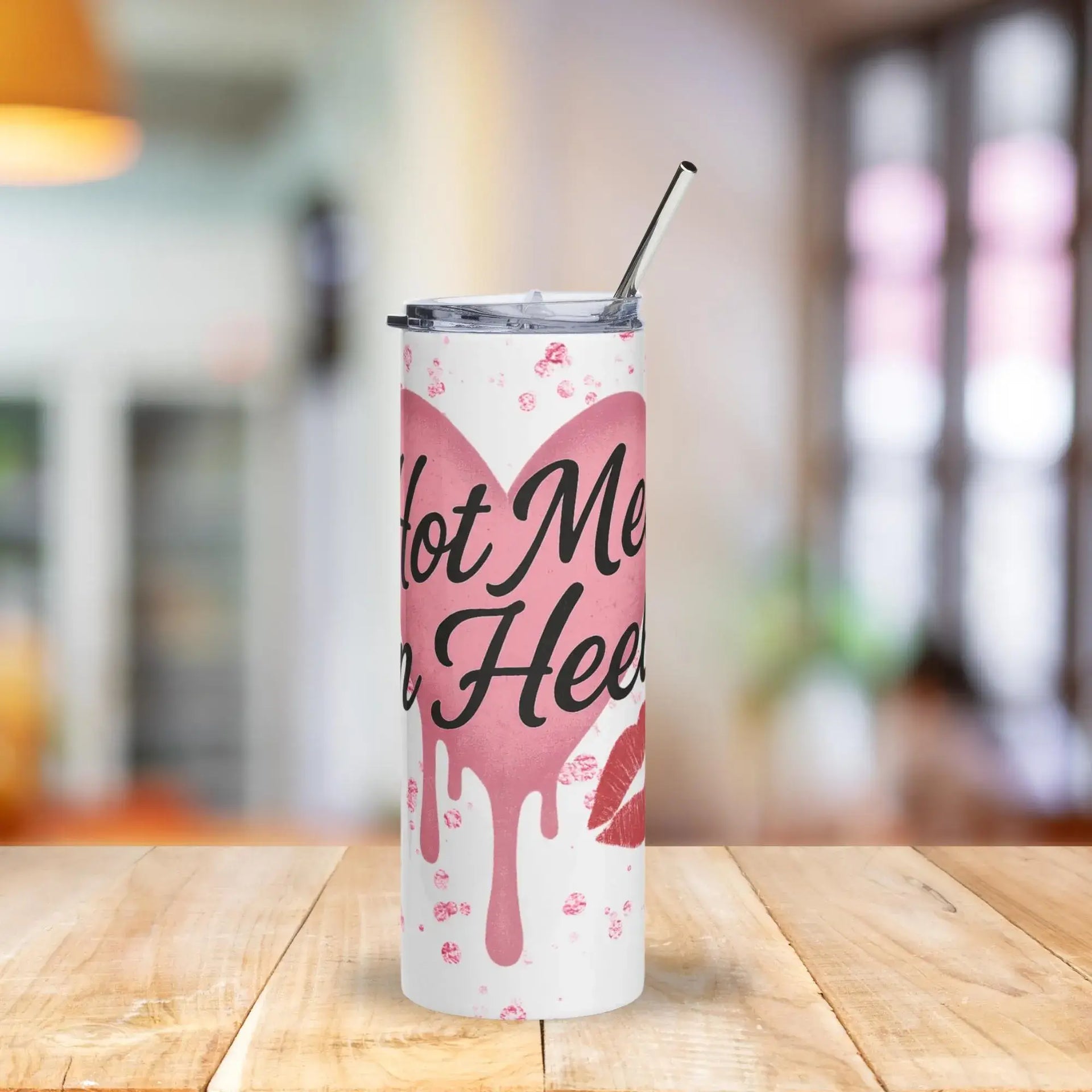 Tumbler with pink heart design and text on a wooden table