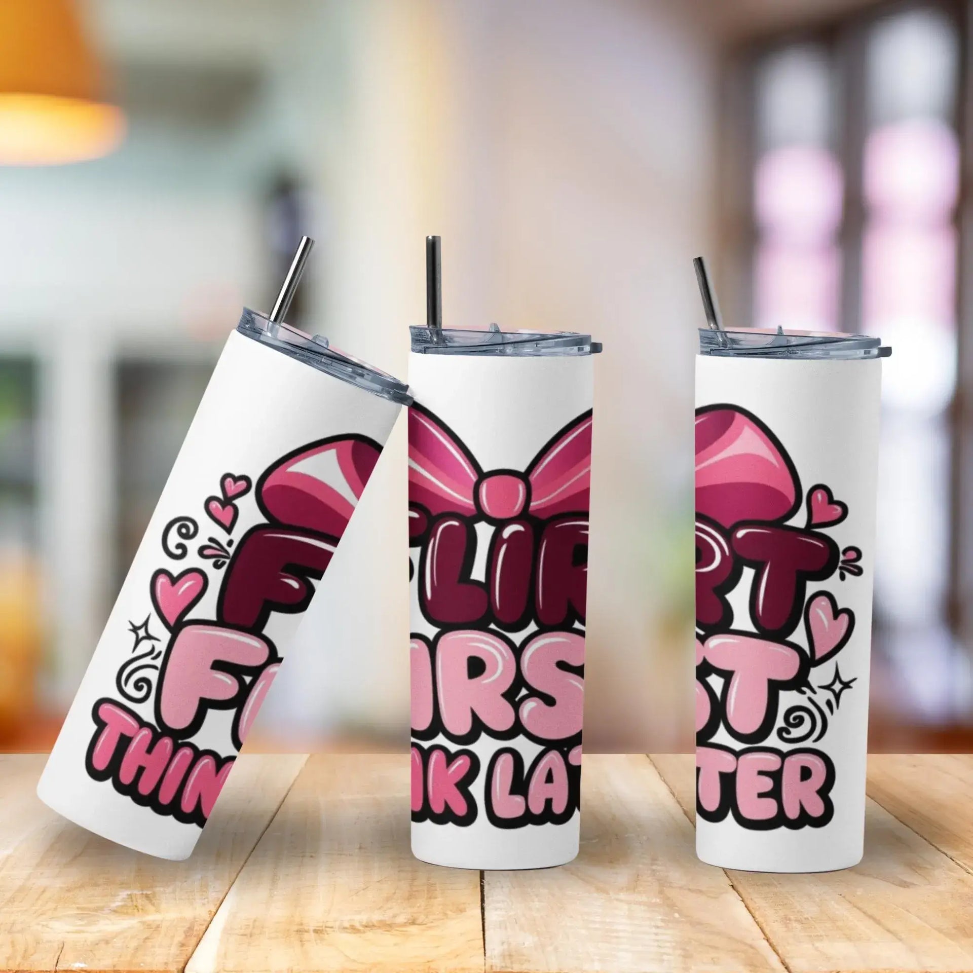 Three insulated tumblers with colorful designs on a wooden surface.