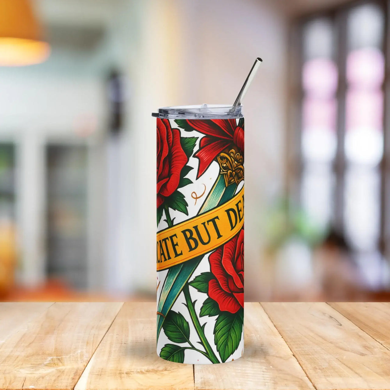 Tumbler with floral design and text on a wooden table with a blurred background