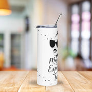 White tumbler with black text and design on a wooden table with a blurred background