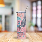 Pink tumbler with decorative design on a wooden table