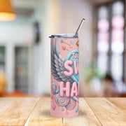 Pink tumbler with colorful design on a wooden table